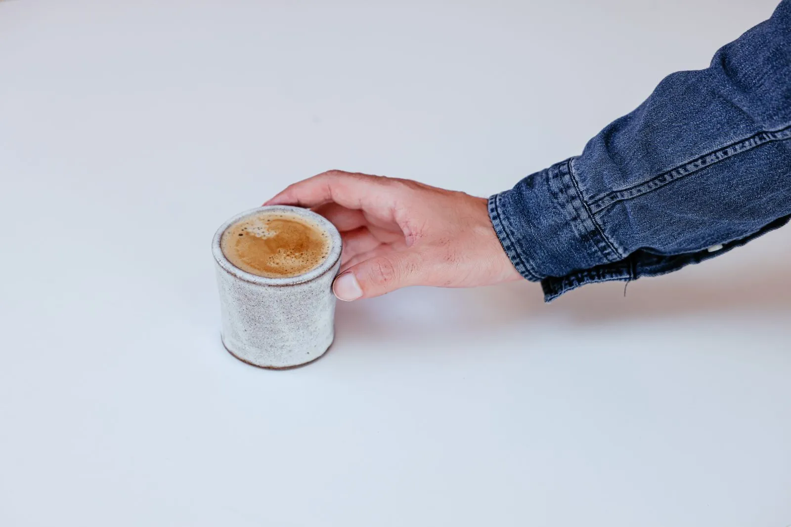 Cortado en taza de concreto sobre fondo claro